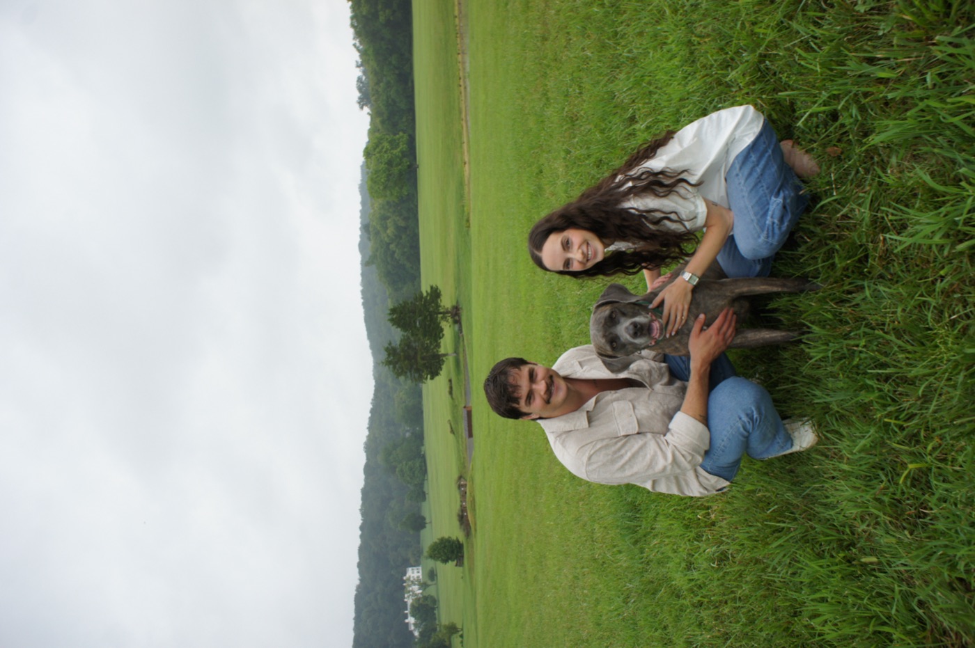 Melanie and Casey in a green field with their dog